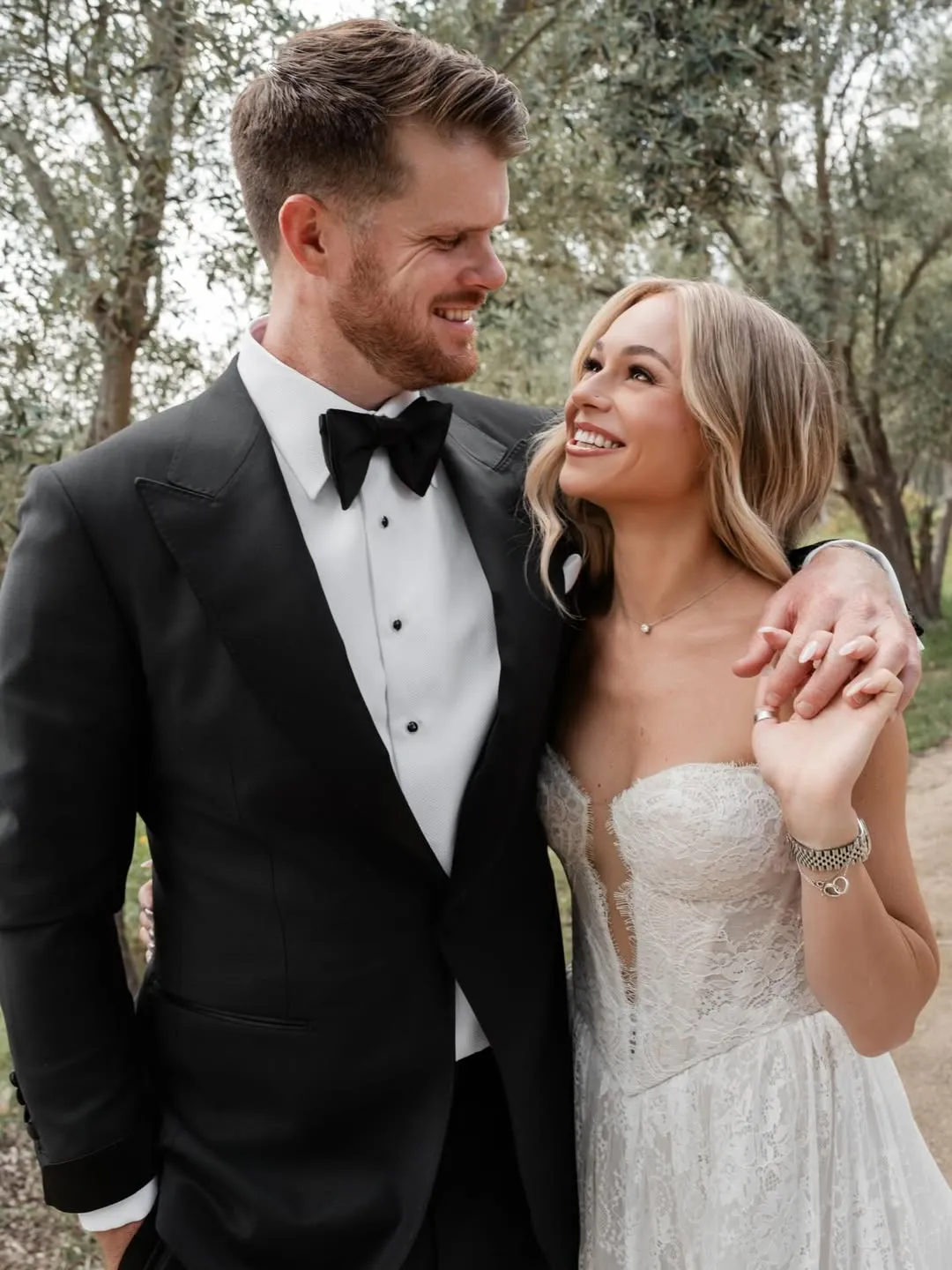 Sam Darnold e esposa Katie Hoofnagle Darnold em seu casamento, vestidos de gala preto e branco.