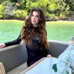 Silhueta de mulher em janela de prédio, com skyline ao fundo, simbolizando a morte da candidata Miss Cosmo Ana Luiza Mateus.