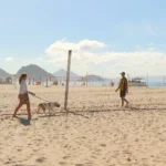 Banhistas e trabalhadores na areia de uma praia do Rio de Janeiro sem informações sobre sua qualidade.