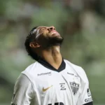 Homem jogando Cartola 2026, analisando jogadores suspensos e lesionados para a rodada 13 do Brasileirão.