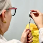 Pessoas sendo vacinadas contra a gripe em uma campanha de imunização.