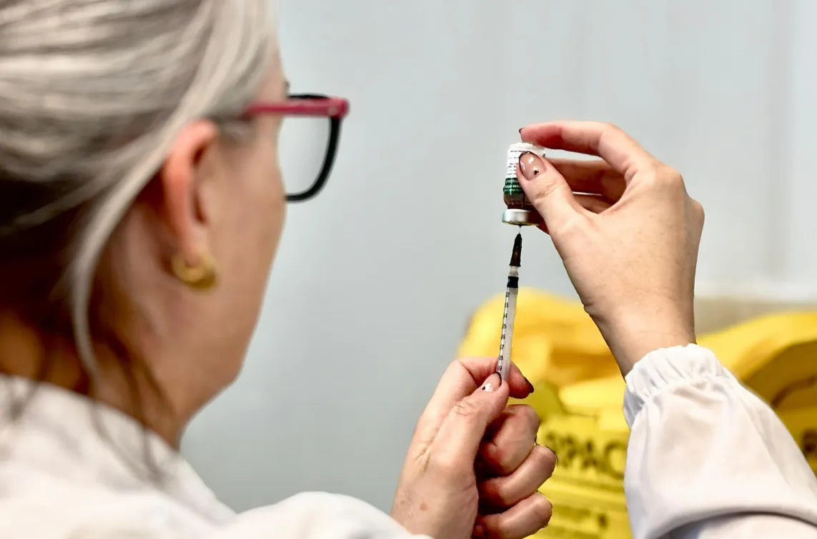 Pessoas sendo vacinadas contra a gripe em uma campanha de imunização.