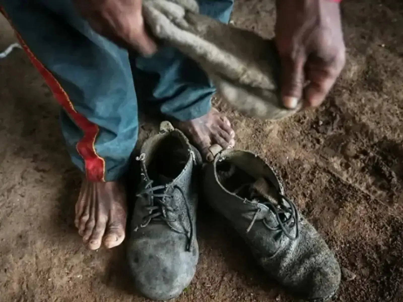 Mão segurando a lista suja do trabalho escravo, com fábrica da BYD ao fundo