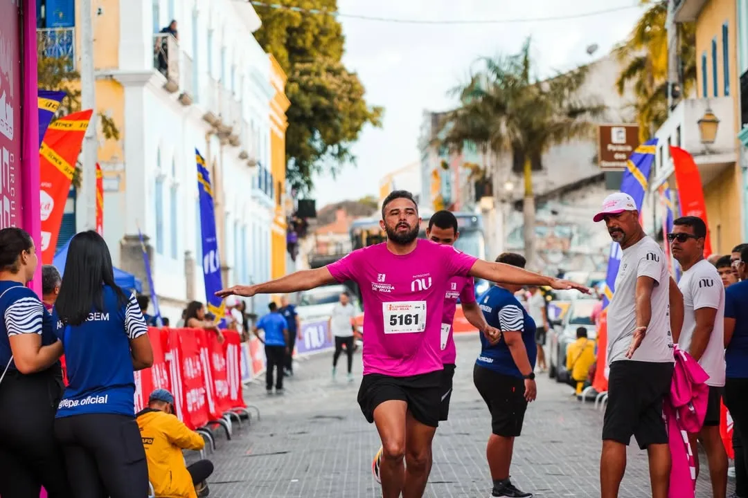 Pessoas correndo em circuito de rua em Caruaru, etapa do Circuito Pernambucano, com foco em esporte e ação social.