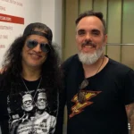 Músico baiano Lucas Ferraz tocando guitarra ao lado de Slash em um show lotado