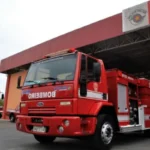Mãos doando gelatina vermelha em campanha de apoio a pacientes oncológicos.