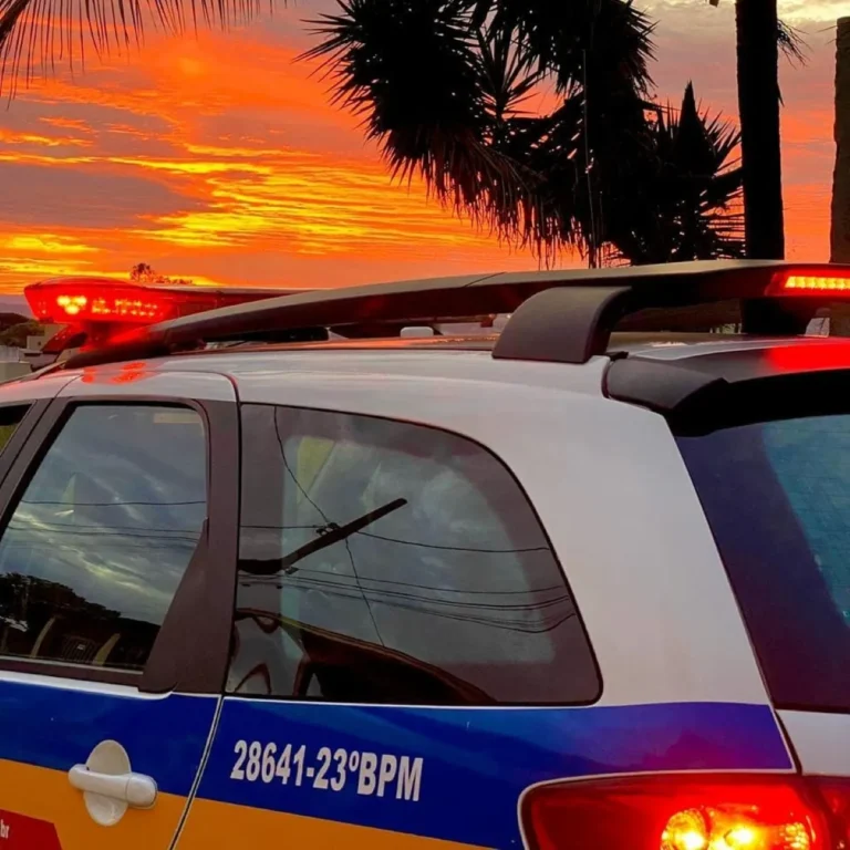 Rua de comunidade em BH com brinquedo no chão e polícia ao fundo após incidente