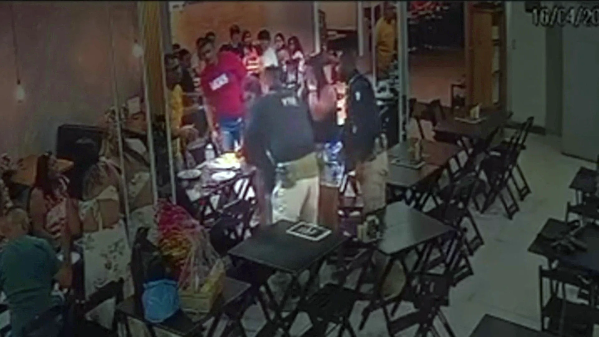 Policial aplicando Heimlich em criança engasgada com pizza