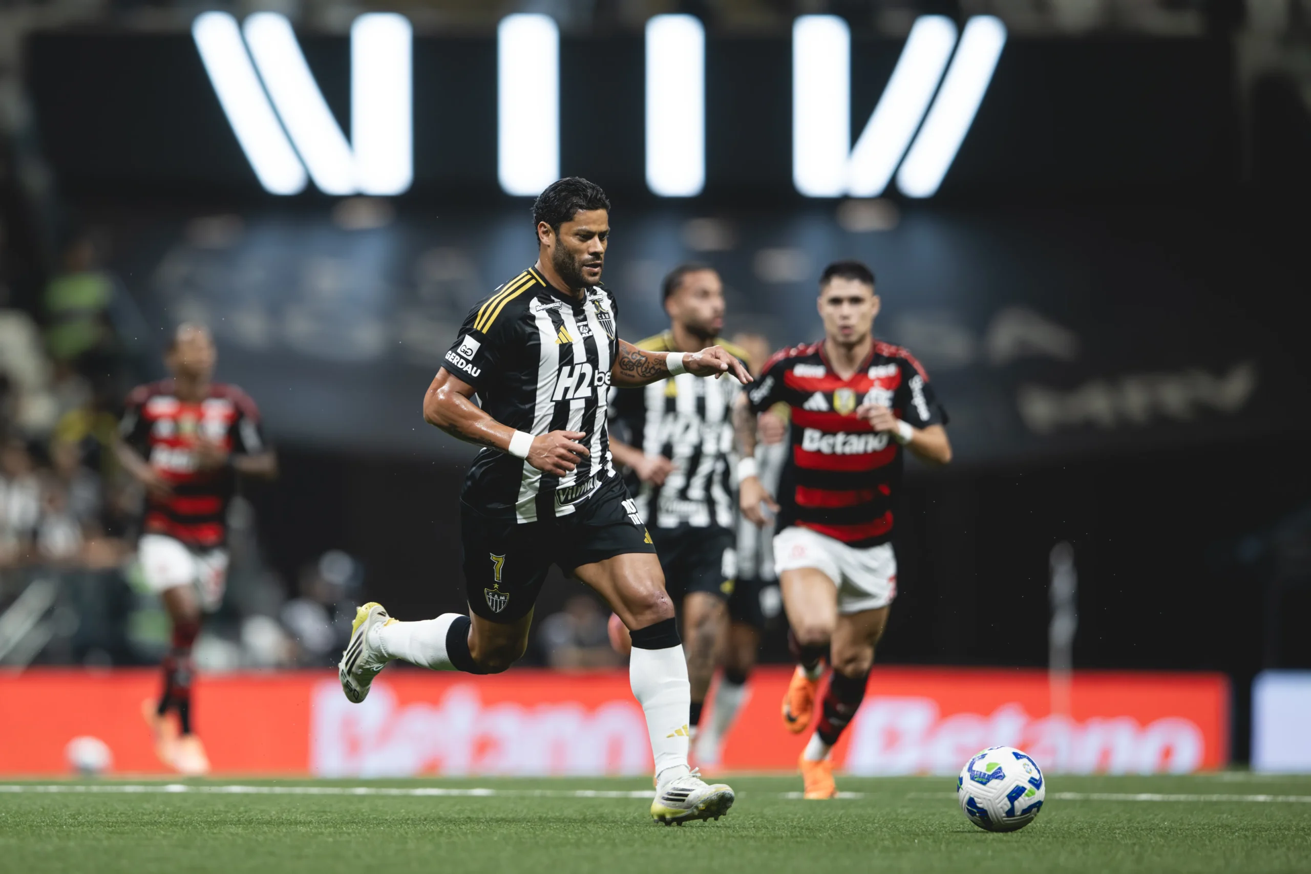 Arena MRV lotada com torcedores de Atlético-MG e Flamengo em partida de futebol.