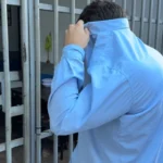 Mãos de policial com algemas e mãos de idoso com cartão de crédito, simbolizando prisão de dentista por golpe.