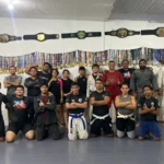 Lutadores de jiu-jítsu em combate durante o Desafio de Lutas Casadas do Tarumã, em Manaus, com destaque para a homenagem à cultura indígena.