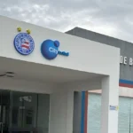 Estádio de futebol com placar eletrônico mostrando balanço financeiro Bahia SAF 2025, crescimento de receita, redução de prejuízo