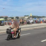 Condutor de autopropelido com duas crianças em via pública