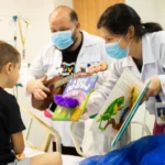 Crianças em hospital leem livros infantis sobre monstros e animais