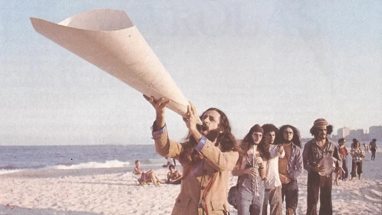 Alceu Valença com megafone na praia em 1975, ao lado de Zé Ramalho, cena do Documentário Vivo 76.
