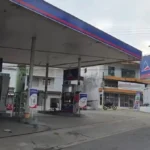 Viaturas da polícia em posto de combustíveis após assalto noturno em Itaperuna, com frentistas prestando depoimento