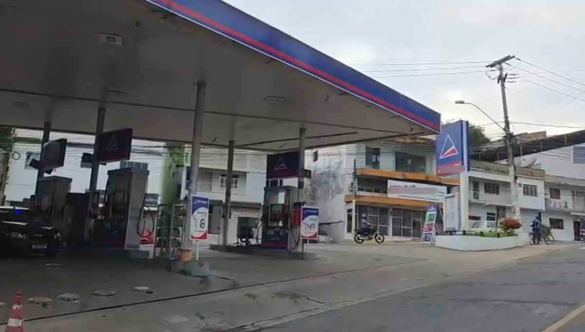 Viaturas da polícia em posto de combustíveis após assalto noturno em Itaperuna, com frentistas prestando depoimento