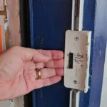 Dois homens presos pela polícia em frente a uma loja de eletrônicos arrombada, com itens furtados.