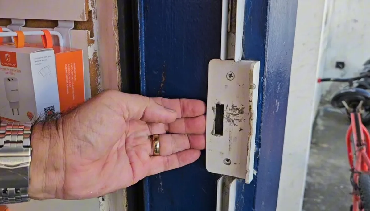 Dois homens presos pela polícia em frente a uma loja de eletrônicos arrombada, com itens furtados.