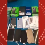 Policiais com celulares e armas apreendidas em frente a uma loja