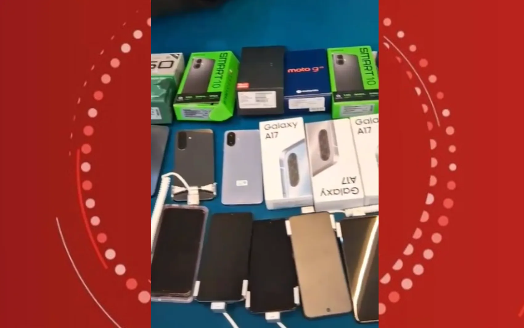 Policiais com celulares e armas apreendidas em frente a uma loja