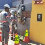 Técnicos da Enel Rio inspecionando medidores e fiação elétrica em Duque de Caxias para identificar furto de energia