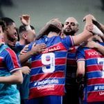 Elenco do Fortaleza em treino, com jogadores disputando a bola e goleiro defendendo, representando a competição interna.