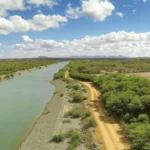 Rio seco recebendo água de comportas abertas, cenário desértico do Iêmen