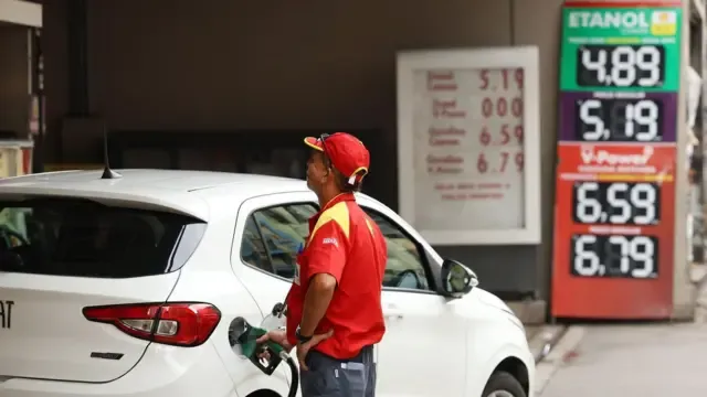 Bomba de combustível diesel com cifrão, representando o aumento do preço e as ações do governo Lula para controle.