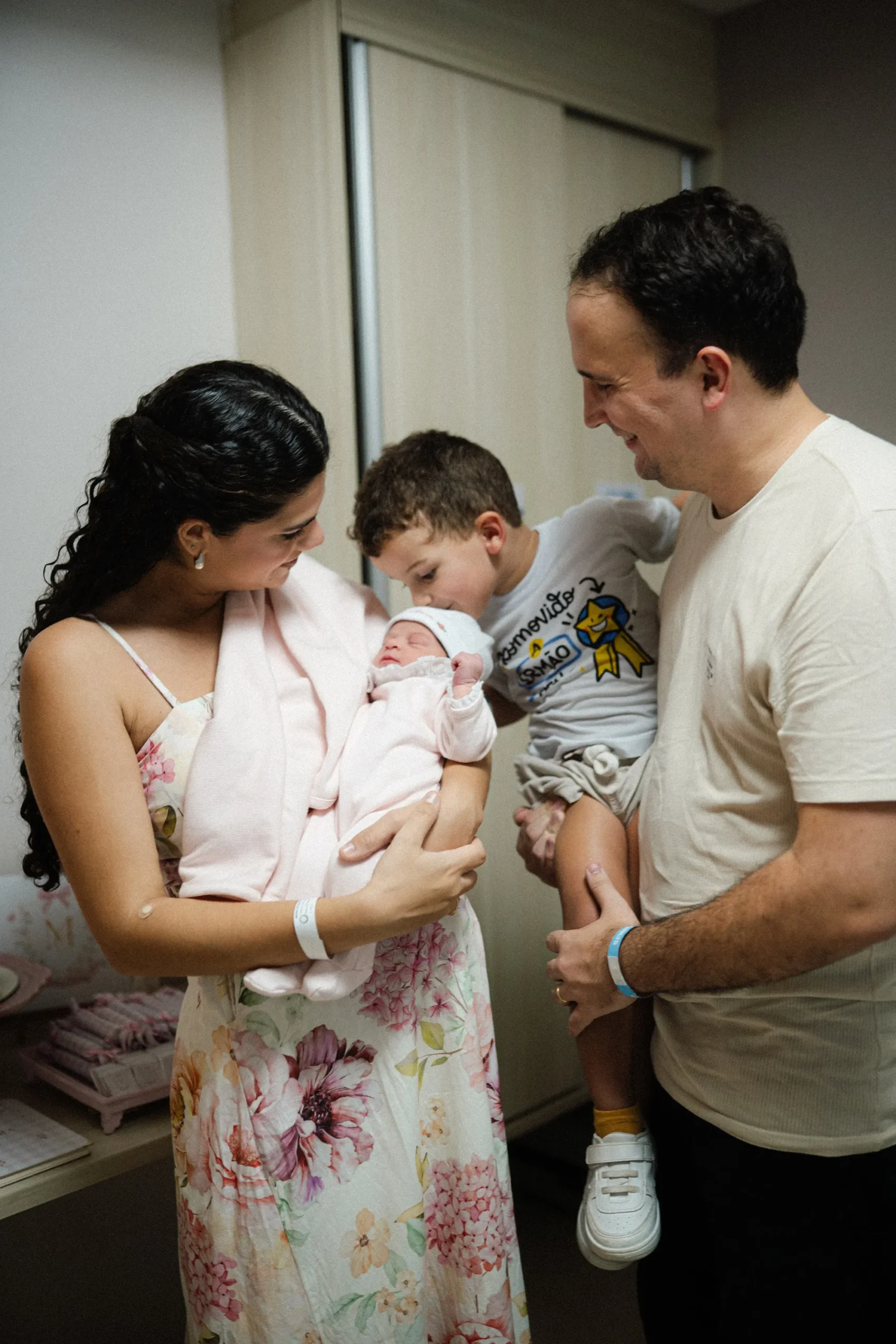 Jovem mãe Maria Eduarda abraça seu bebê recém-nascido após um parto rápido no banheiro de casa, com um olhar de superação e amor.