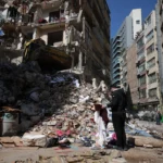 Homem em meio a escombros de edifício destruído em Beirute, Líbano, após ataque de Israel.
