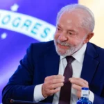 Lula segurando uma jabuticaba, fruta brasileira