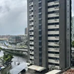 Pessoas com guarda-chuvas em uma rua de Salvador sob forte chuva