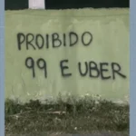 Celular com aplicativo de transporte e fundo urbano hostil