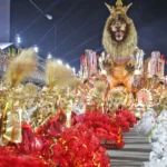 Desfile de escola de samba no Carnaval do Rio com muitas pessoas e alegorias coloridas