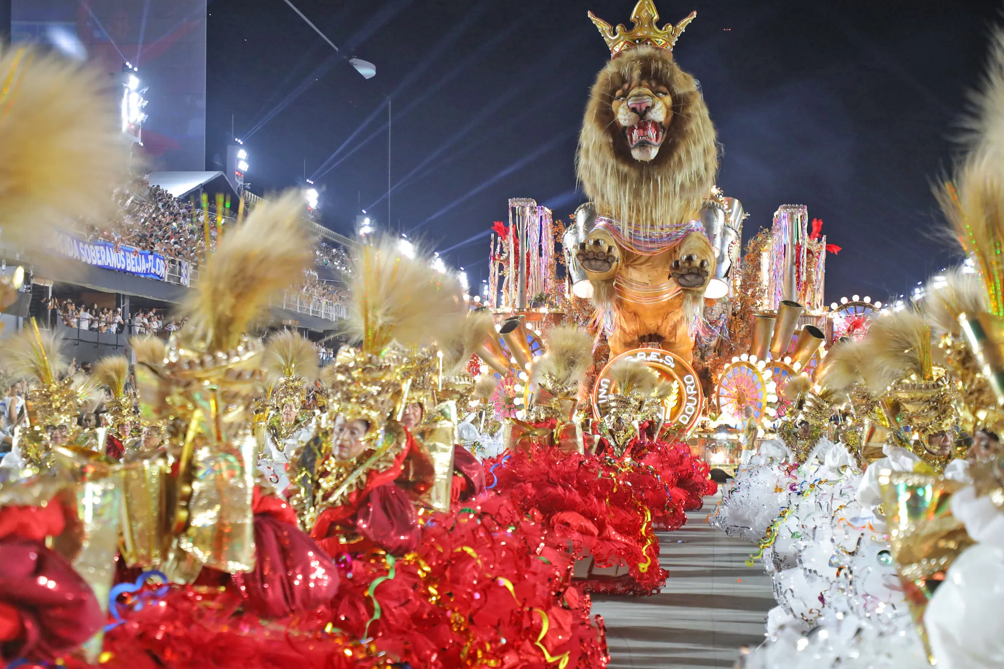 Desfile de escola de samba no Carnaval do Rio com muitas pessoas e alegorias coloridas