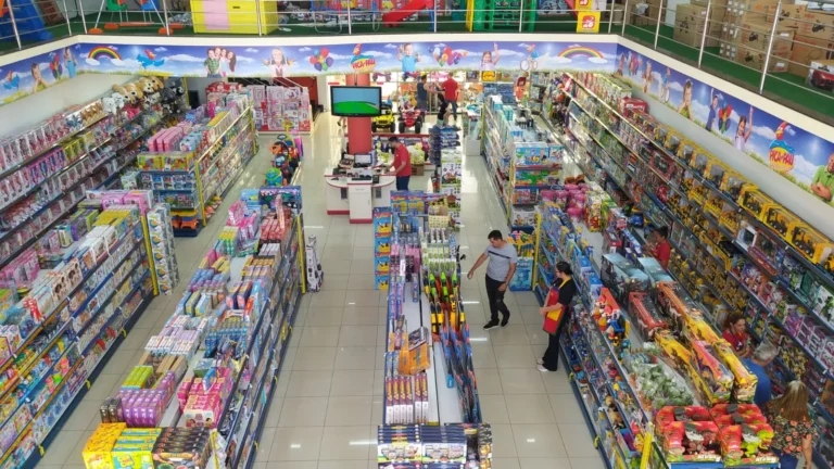 Rua movimentada de comércio com pessoas comprando, lojas abertas, placas de Páscoa, em Piracicaba ou Limeira