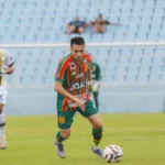 Jogador Esquerdinha do Sampaio Corrêa em campo de futebol com a bola