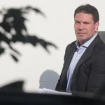 Retrato de delegado brasileiro em cenário diplomático nos EUA, relacionado a extradição.