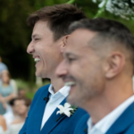 Felipe Suhre e Erick Andrade sorrindo em seu casamento, trocando alianças