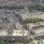 Vista da fábrica Vulcan abandonada no Rio, mostrando telhados e esquadrias removidos, lixo e água parada em Colégio.