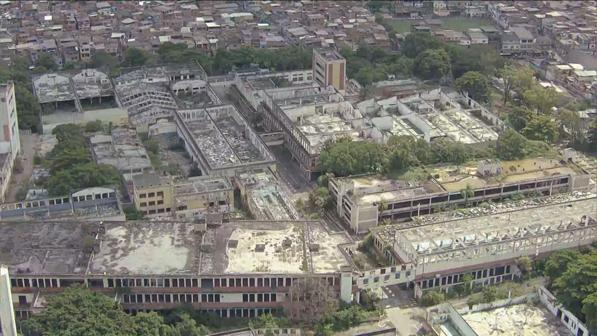 Vista da fábrica Vulcan abandonada no Rio, mostrando telhados e esquadrias removidos, lixo e água parada em Colégio.