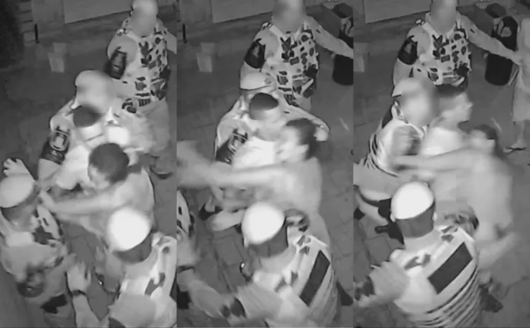 Dois policiais militares entrando em uma casa à noite, capturados por câmera de segurança, enquanto um membro da família observa a invasão.