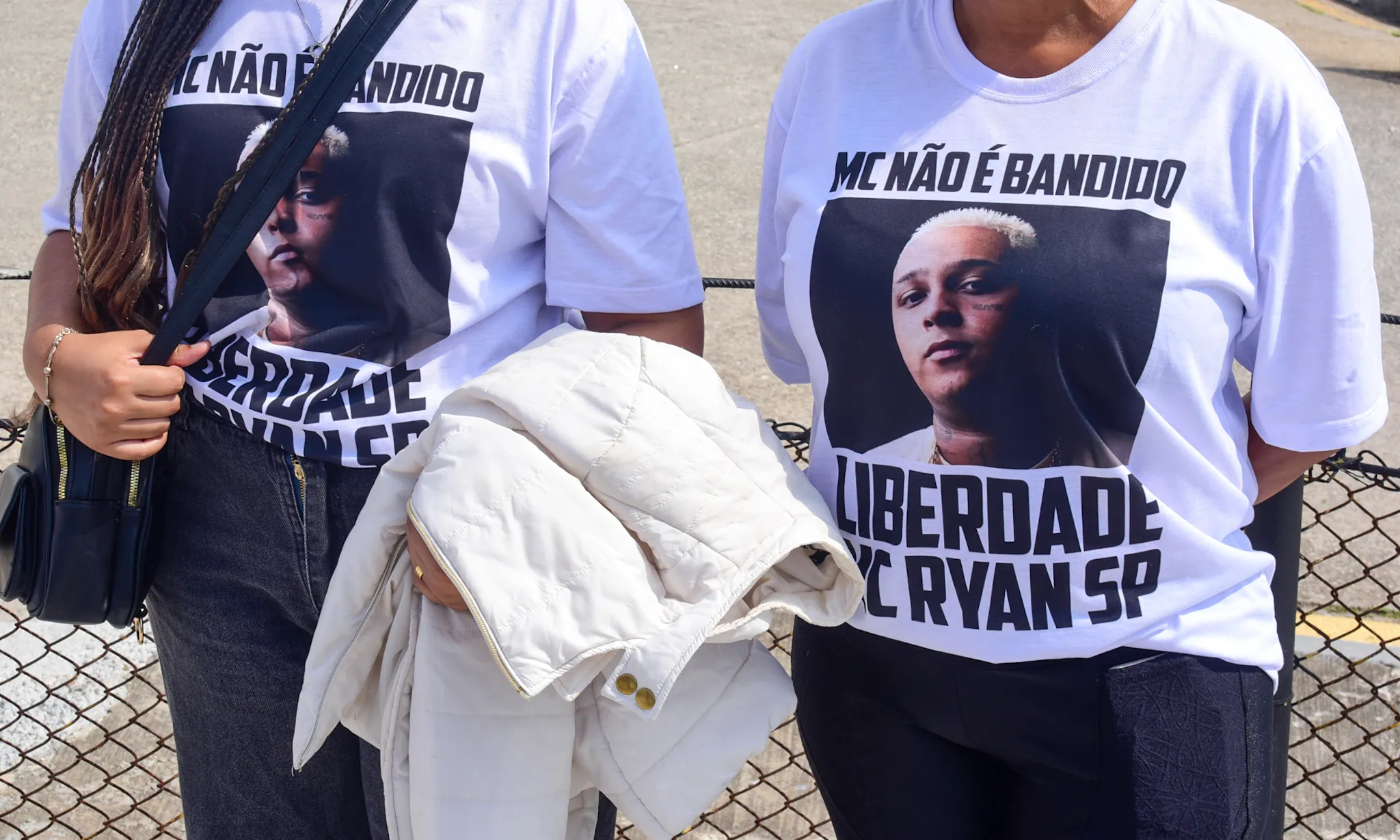 Familiares de MC Ryan SP com camisetas e faixas pedindo sua liberdade