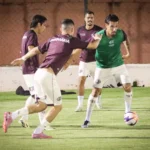 Time da Ferroviária em jogo da Série A2, com uniformes grená, em campo de futebol.