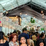 Pessoas comprando e vendendo malhas na FestMalhas em Jacutinga, Minas Gerais