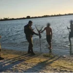 Barco da Guarda Municipal removendo redes de pesca ilegal na Lagoa de Araruama durante o período de defeso
