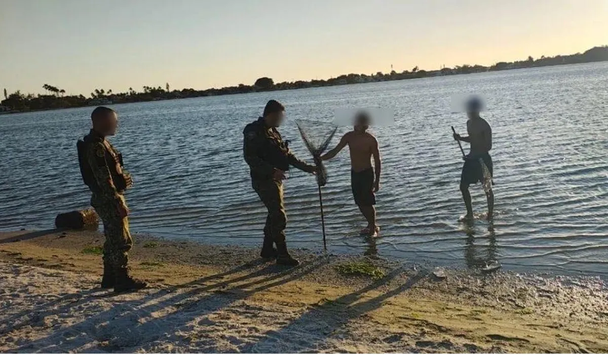 Barco da Guarda Municipal removendo redes de pesca ilegal na Lagoa de Araruama durante o período de defeso