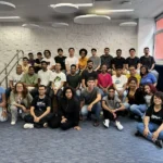 Grupo de estudantes participando do programa de programação da Ford em Salvador, utilizando computadores.