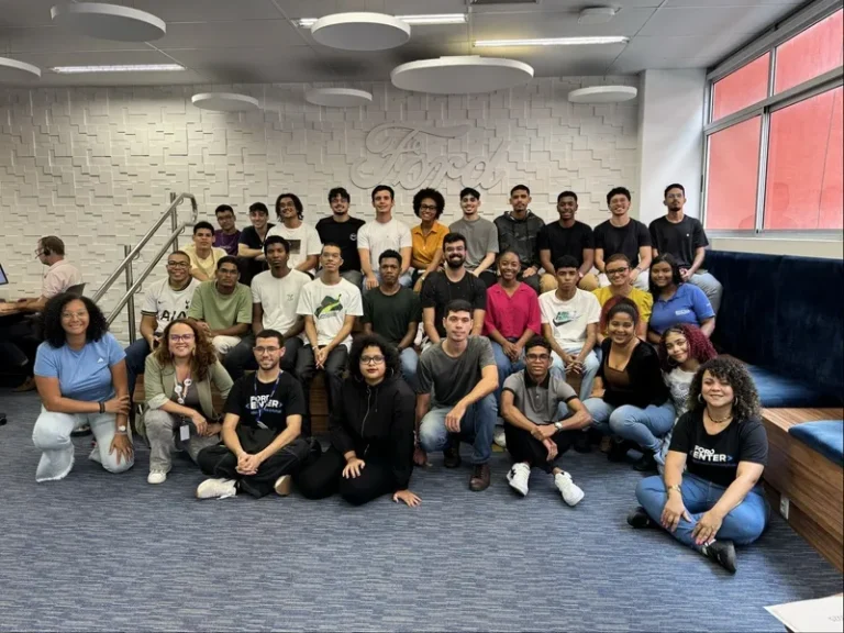 Grupo de estudantes participando do programa de programação da Ford em Salvador, utilizando computadores.